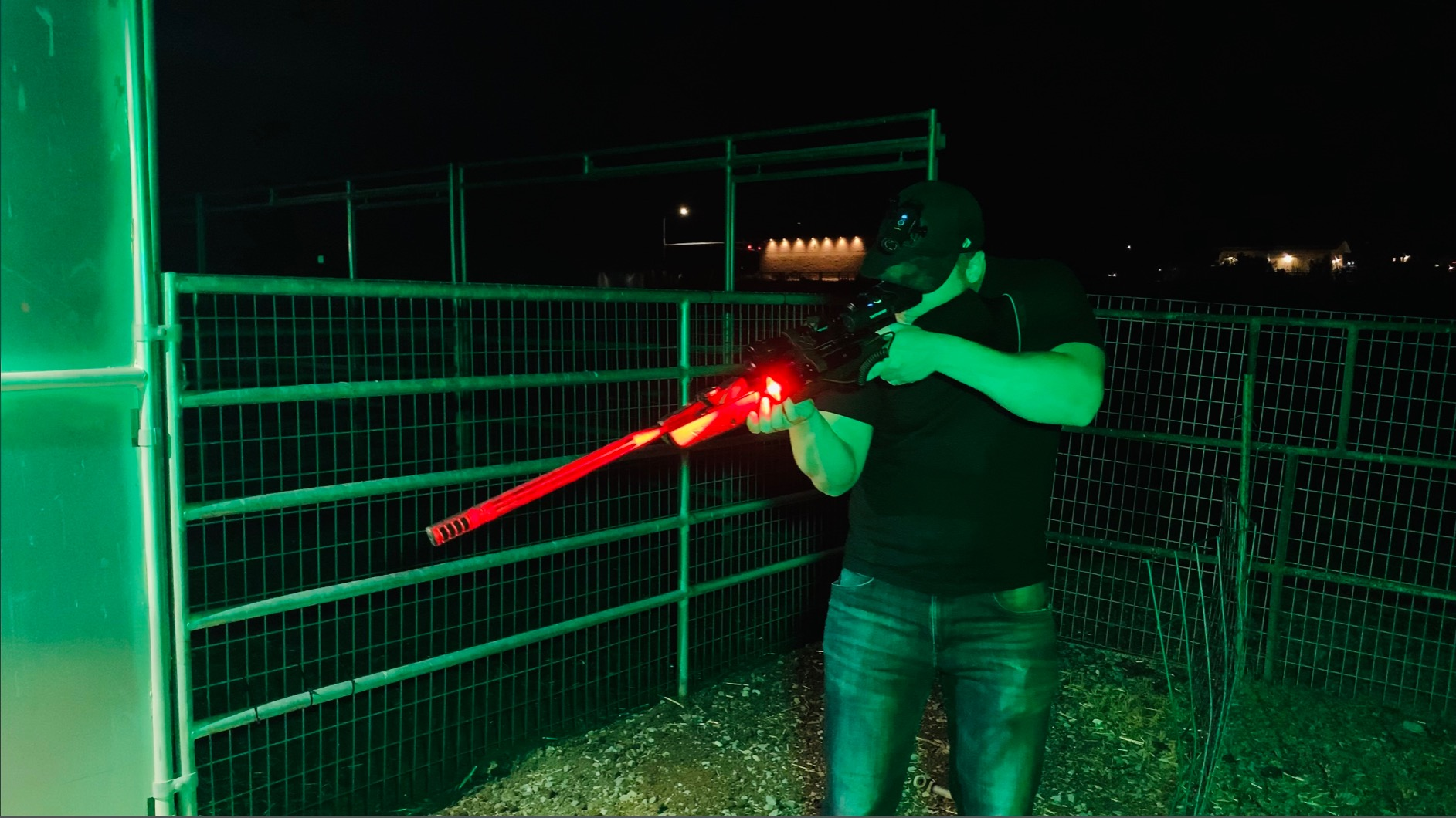 Hunter scanning a dark field with a Brinyte green light hunting flashlight during night hunting season